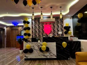 a lobby with a table with yellow and black balloons at Hotel East park Electronic City in Bangalore