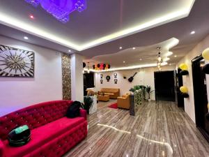 a living room with a red couch in a room at Hotel East park Electronic City in Bangalore