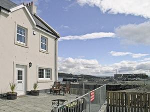 a house with a patio with a table and chairs at Seaview in Garlieston