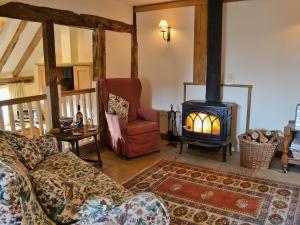 a living room with a couch and a wood stove at Mount House Barn in Burwash