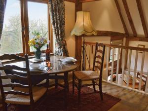 comedor con mesa, sillas y ventana en Mount House Barn, en Burwash