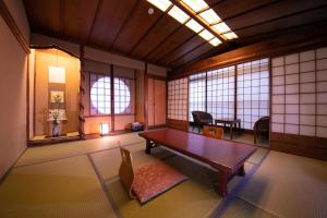 京都市にある京の宿北海館　お花坊のテーブルと椅子、窓が備わる客室です。