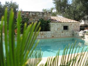 een huis en een zwembad met een gebouw bij Masseria Asciano in Ostuni
