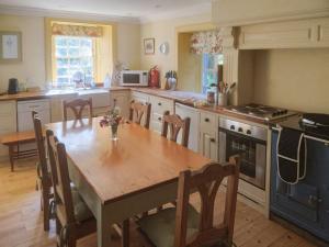 a kitchen with a wooden table and a dining room at Forget Me Not - Skkz in Dalmellington