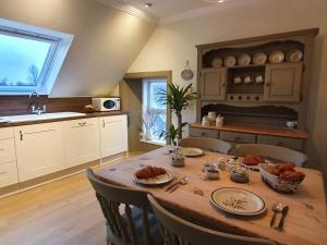 una cocina con una mesa de madera con comida. en Ben Ledi View en Callander