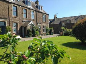 an old brick house with a green lawn in front of it at Ben Ledi View in Callander