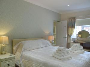 1 dormitorio con 1 cama con toallas en The Annexe, en Clacton-on-Sea