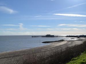 a beach with a pier in the water at The Annexe in Clacton-on-Sea