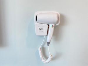 a white phone is hanging on a wall at BENUTTEN 99 HOTEL in Kampong Parit Tengah