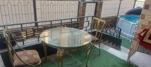 un tavolo in vetro e sedie su un balcone con piscina di Gardinia City luxury Home with 3bed rooms and private pool a Il Cairo