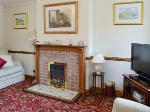 uma sala de estar com lareira e televisão em Cow Pasture Cottage - Uk2297 em Ebberston