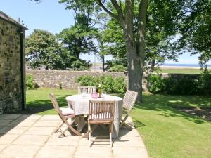 a table with chairs and a bottle of wine on it at Beach View in Bamburgh