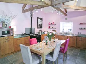 a kitchen with a wooden table with pink walls at Beach View in Bamburgh