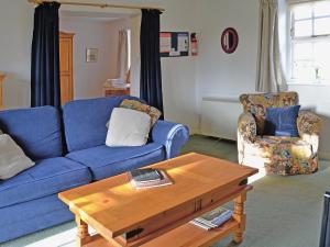 a living room with a blue couch and a coffee table at Smittergill in Ousby