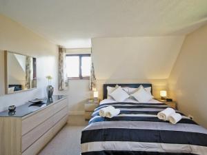 a bedroom with a large bed with towels on it at Pine View - E5473 in Cromer