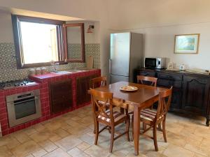 a kitchen with a table and chairs and a refrigerator at Mina' Alfarah in Pantelleria +7 photos