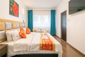 sypialnia z dużym białym łóżkiem z kolorowymi poduszkami w obiekcie Manantial Hostal No.004 w mieście Lima
