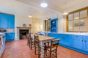 een keuken met blauwe kasten en een tafel en stoelen bij The Generals Quarters in Shrewsbury