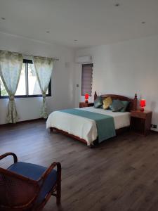 1 dormitorio con 1 cama, 1 silla y ventanas en Beautiful House with private pool in Mauritius, en Albion
