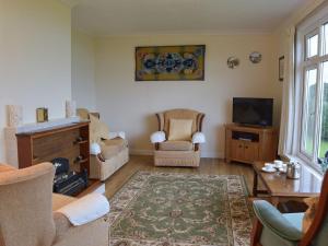 a living room with two chairs and a television at Arforwest in Llangranog