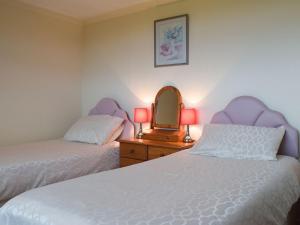een slaapkamer met 2 bedden, een spiegel en een dressoir bij Arforwest in Llangranog