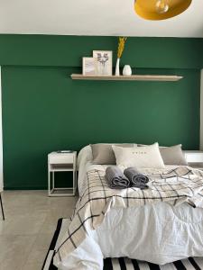 Dormitorio verde con cama y pared verde en Juan Pablo IX en Posadas