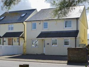 a white house with a black roof at North Shore in Crantock