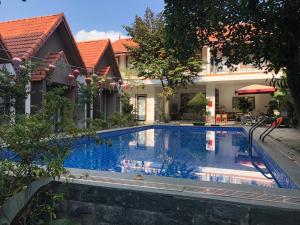 une grande piscine en face d'un bâtiment dans l'établissement Tam Coc Hao Hao Homestay, à Vũ Lâm