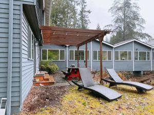 a patio with two chairs and awning on a house at Livable D near Lake Washington in Lake Forest Park