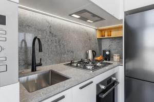 a kitchen with a sink and a stove at Meriton Suites George Street, Parramatta in Sydney