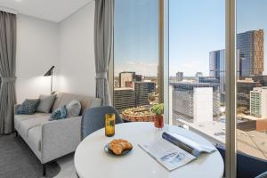 a living room with a couch and a table at Meriton Suites George Street, Parramatta in Sydney