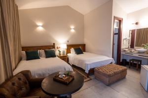 une chambre d'hôtel avec deux lits et un canapé dans l'établissement Pousada Pequena Tiradentes, à Tiradentes