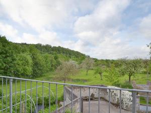 - une vue sur une colline avec une clôture et des arbres dans l'établissement Little Burcott Loft, à Wookey