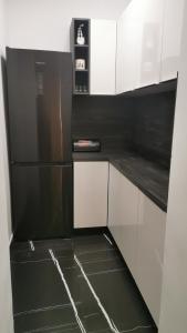 a black and white kitchen with a black refrigerator at Apartment Deni in Pula