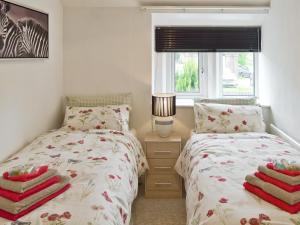 a bedroom with two twin beds and a window at Tree Tops in Youlgreave