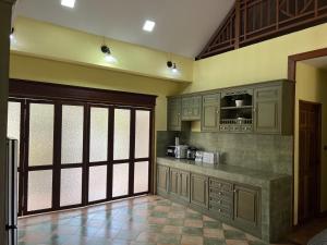 a kitchen with wooden cabinets and a counter top at บ้านทรายแก้ว 129HOUSE in Klaeng
