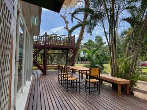 una terraza de madera con mesa y sillas de madera en บ้านทรายแก้ว 129HOUSE en Klaeng