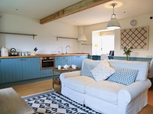 a living room with a white couch in a kitchen at The Granary in Crocketford