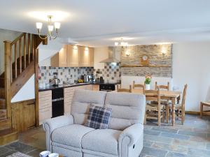 a living room with a couch and a table and a kitchen at Bryntrisant in Devils Bridge