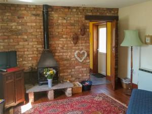 a living room with a brick wall and a fireplace at The Shepherds Bothy in Tetford