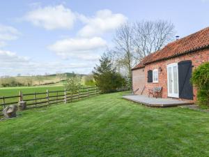 een stenen huis met een tuin en een hek bij The Shepherds Bothy in Tetford