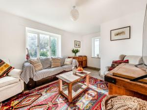 a living room with a couch and a table at 4 Cromwells Cottage-uk40933 in Pembroke