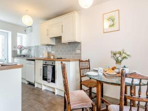een keuken met een tafel en stoelen in een kamer bij 4 Cromwells Cottage-uk40933 in Pembroke