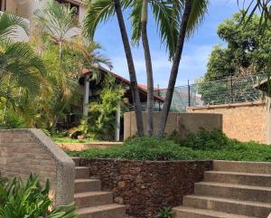 a set of stairs in front of a house with palm trees at L Otro Pueblo Pampatar in Pampatar