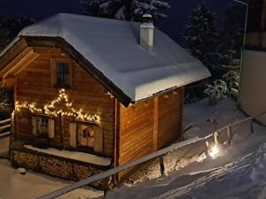 トゥルラッハー・ヘーエにあるSki in ski out chalet on the Turracher Hoeheのクリスマスライト付きのログキャビン