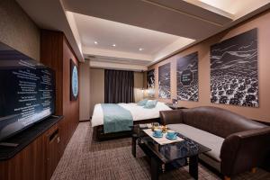 a hotel room with a bed and a flat screen tv at Hotel WILL BASE 旧Chambery in Yokohama