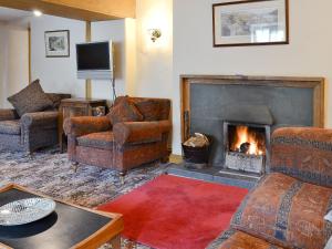 uma sala de estar com cadeiras e uma lareira em Brothersfield Cottage em Patterdale