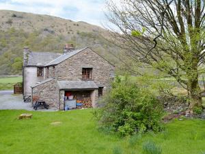 an old stone house in the middle of a field at Brothersfield Cottage in Patterdale