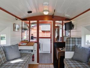 a living room in a rv with two couches and a table at The Guards Van in Wetheringsett