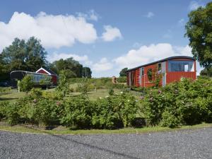 a red train car in a garden with flowers at The Guards Van in Wetheringsett